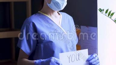 戴着医用面具和制服的人慢慢地拿起一张纸，上面写着`你们都会死，然后笑。 疯狂笑话